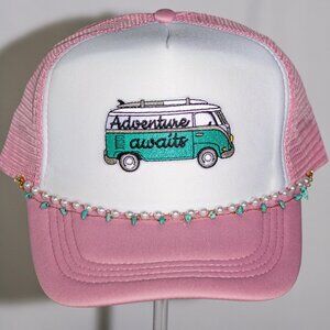 Pink and white "Adventure Awaits" trucker hat with hat jewelry
